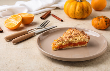 Plate with piece of fresh pumpkin pie on light background
