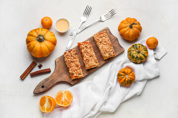 Wooden board with pieces of tasty pumpkin pie on white background