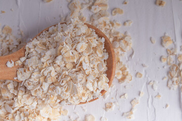 oatmeal in wooden spoon and fresh milk on white background healthy food