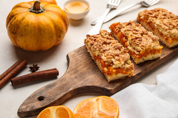 Wooden board with pieces of tasty pumpkin pie on white background, closeup
