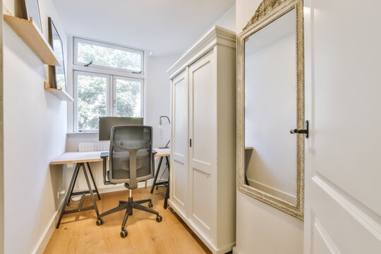Small room with a miniature window and a desk for office work
