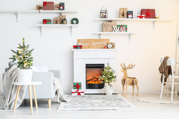 Interior of light living room with fireplace and Christmas trees