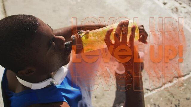 Animation of level up text over african american sportsman drinking water