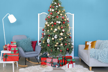 Interior of modern room with Christmas tree and gift boxes near blue wall