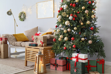 Christmas tree, gift boxes and sofa near light wall