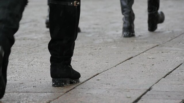 People's feet walk along the sidewalk of the winter street of the big city