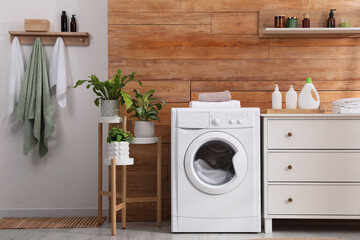 Laundry room interior with washing machine and stylish furniture - obrazy, fototapety, plakaty
