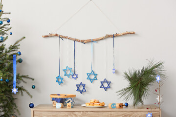 Beautiful decorations and donuts for Hanukkah celebration on table in room