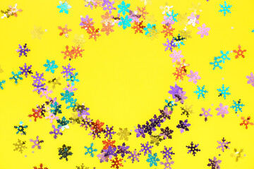 Frame made of colorful confetti on yellow background
