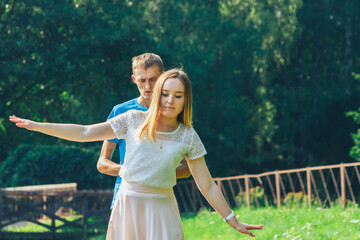 Obraz premium A couple in love walks in a summer park by the lake.A man supports his woman.