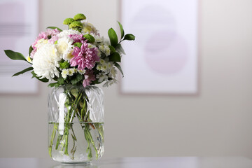 Bouquet of beautiful chrysanthemum flowers on table in room, space for text