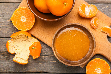 Bowl of tasty tangerine jam on wooden background