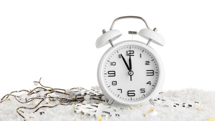 Alarm clock and Christmas decorations on snow against white background