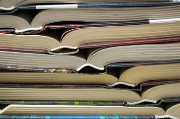 open hardcover books are stacked vertically on top of each other. The concept of loving books, reading books