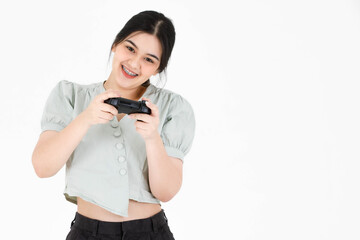 Portrait closeup studio shot of Asian young happy teen female model with ponytail hairstyle wearing dental care teeth braces and casual crop top outfit hold joystick playing game on white background