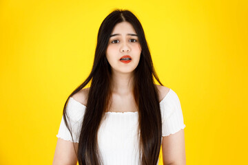 Portrait close up studio shot of Asian young beautiful sexy long black hair female model wearing dental care teeth braces and crop top outfit standing smiling look at camera on yellow background