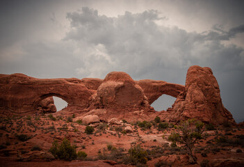 Fototapeta premium View of North and South Windows Arch, storm clouds in the sky, Arches National Park, Utah, USA