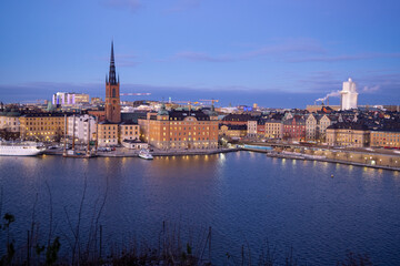 Beautiful panorama of Stockholm at night with sea, buildings, boats and night city lights. Capital of Sweden photographed from the hill. 