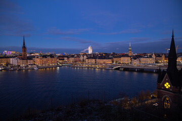 Fototapeta na wymiar Beautiful panorama of Stockholm at night with sea, buildings, boats and night city lights. Capital of Sweden photographed from the hill. 