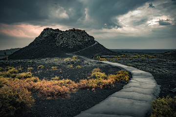 View of the spray cone trail on the horizon, lava hills, volcanic landscape at the National Reserve of the Moon and Craters, Idaho, USA © Володимир Маценко