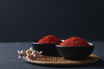 Korean red chili powder in a bowl on black background, Chili flakes