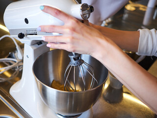 Woman hands whipping with mixer. Making dessert in modern kitchen