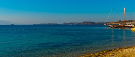 BODRUM, TURKEY: Beautiful seascape with a view of the ship and the mountains on the horizon in Bodrum on a sunny day.