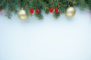 Fototapeta na wymiar Merry Christmas and Happy New Year white background with green fir branches, bows and balls. Christmas tree flatly. Flat lay, top view, copy space.
