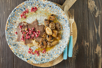 Roast beef with mushrooms and pomegranate seeds. French gourmet cuisine
