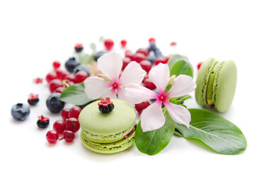 A scattering of juicy berries, flowers and macarons.