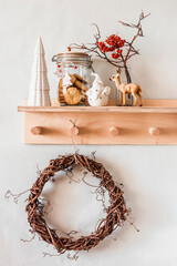 Christmas kitchen home decor composition on a wooden shelf in the interior of a scandinavian style room with homemade  wreath