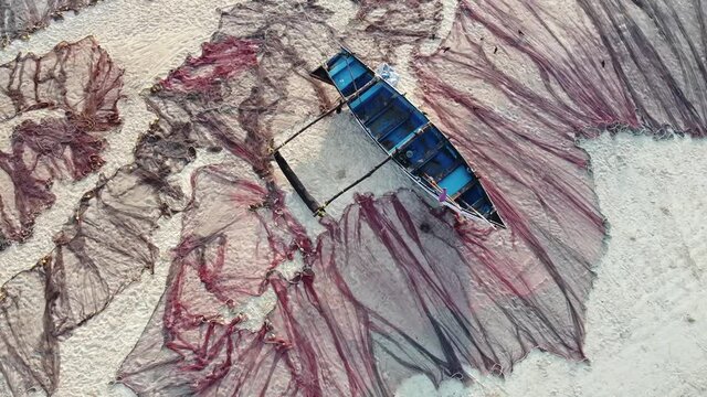 A fishing boat on the beach surrounded by a large fishing net left to dry at Betalbatim, Goa India.