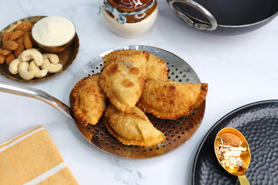 Indian Holi snack popuraly known as Gujia or Gujiya. Also called Karanji in Maharashtra, mostly eaten during Diwali. It is a deep fried sweet dish made from maida and stuffed with khoya or rava. copy.