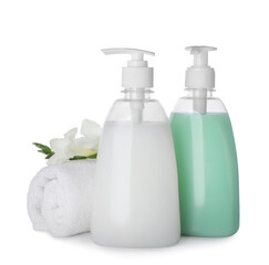 Dispensers of liquid soap, rolled towel and freesia flowers on white background