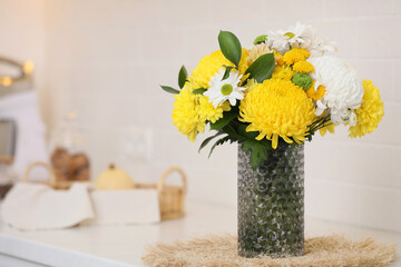 Fototapeta na wymiar Bouquet of beautiful chrysanthemum flowers on countertop in kitchen, space for text