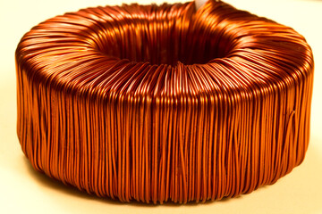 Toroidal transformer with a winding of copper wire of bright color.