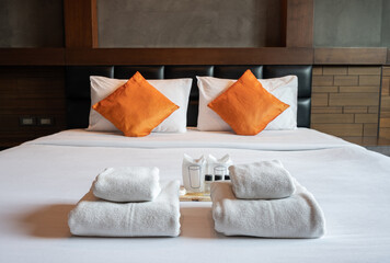 Set of hotel amenities (such as towels, shampoo, soap etc.) on the bed in hotel bedroom. Hotel...