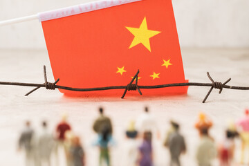 China flag, barbed wire and plastic toy men, illegal migration concept