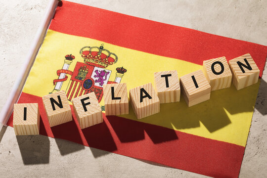 Spanish flag and wooden cubes with text on an abstract background, concept on the topic of inflation in Spain