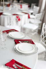 Beautiful festive table setting with napkins of different colors. A luxurious dining set with cutlery, napkin, dishes and covered with a tablecloth in the restaurant. Gold plates and crystal glasses. 