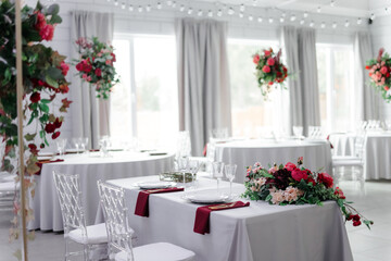 Beautiful festive table setting with napkins of different colors. A luxurious dining set with cutlery, napkin, dishes and covered with a tablecloth in the restaurant. Gold plates and crystal glasses. 