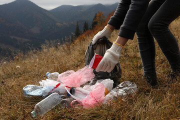 Woman with trash bag collecting garbage in nature, closeup