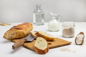French baguette slices and a knife on a cutting board.