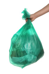 Woman holding trash bag filled with garbage on white background, closeup