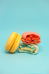 yellow, blue orange macarons on a light blue background. sweets as a gift. preparation for the celebration. fresh and delicious desserts.