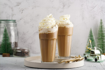 Two tall glasses with cold coffee drink frappe - iced cappuccino with whipped cream, christmas...