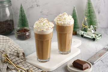 Two tall glasses with cold coffee drink frappe - iced cappuccino with whipped cream on a marble...