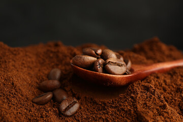 Coffee grounds and roasted beans on dark background, closeup