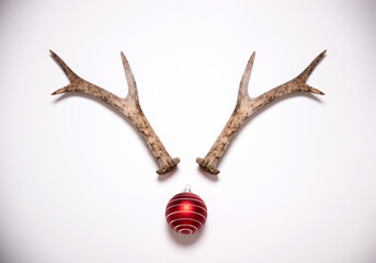Christmas reindeer concept made of antlers and red bauble decoration
