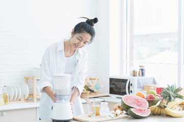 young woman using a blender in the kitchen.